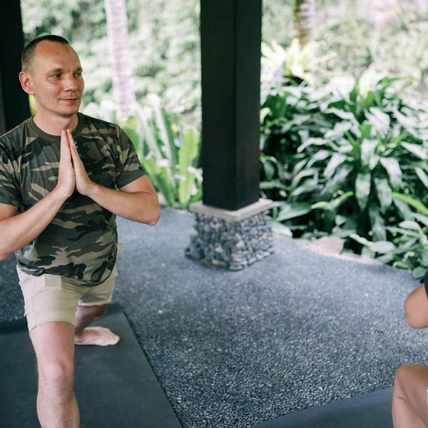 Man stretching outdoors with a look of calm focus and energy.